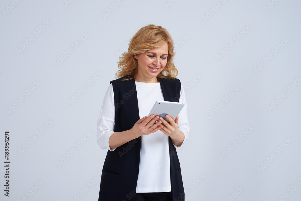 Smiley mature woman using tablet pc Smiley mature woman using tablet pc
