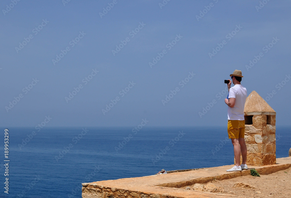 Tourist taking pictures of the sea on the phone Tourist taking pictures of the sea on the phone