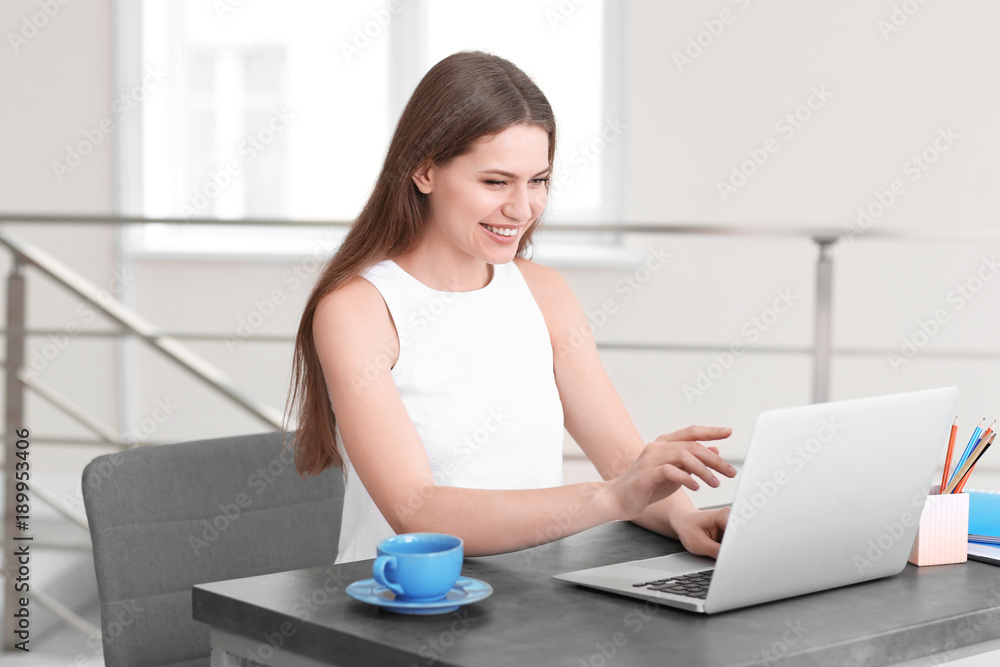 Young woman using laptop indoors Young woman using laptop indoors