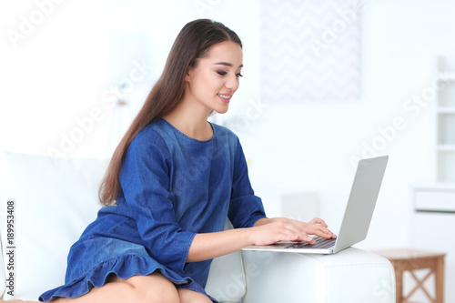 Smiling young woman using l...