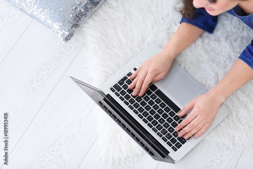 Woman using laptop indoors, closeup