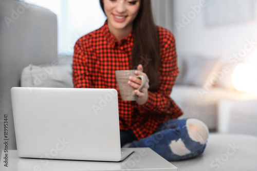 Young woman using laptop in...