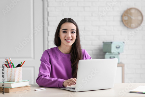 Young woman using laptop indoors © Africa Studio