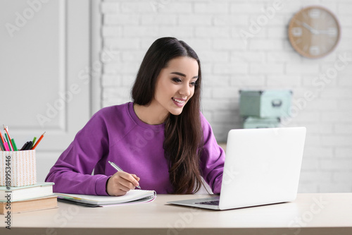 Young woman using laptop in...
