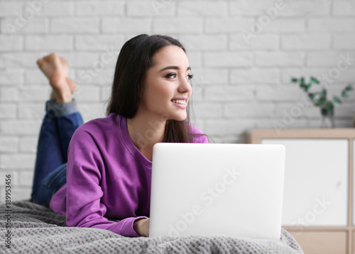 Young woman using laptop in...
