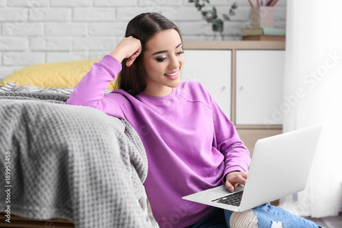 Young woman using laptop in...
