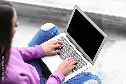 Woman using laptop indoors,...