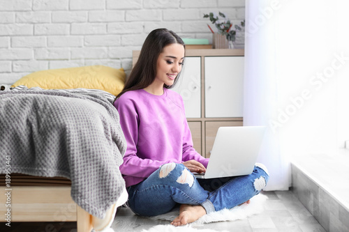 Young woman using laptop in...