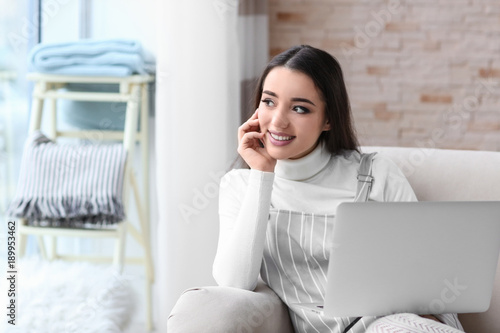 Young woman using laptop in...