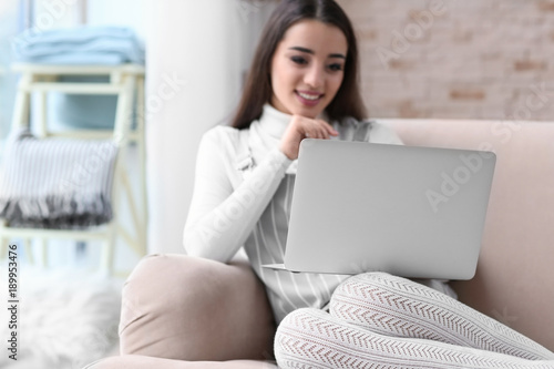 Young woman using laptop in...