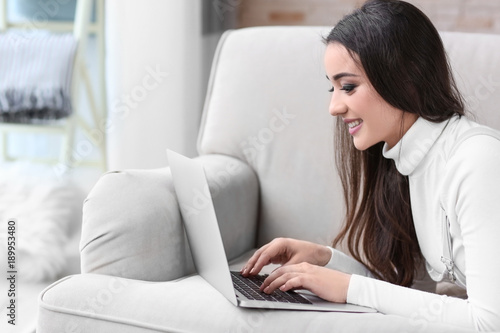 Young woman using laptop in...