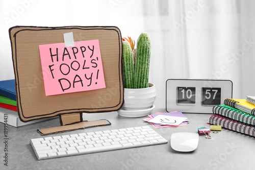 Computer with cardboard monitor on office table. April fool's day celebration