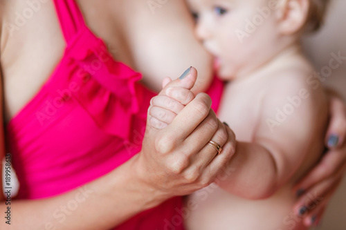 Soft focus and blurry of baby hands touch mother hand while breastfeeding
