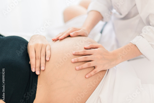 Female Obstetrician doctor Examination  to a pregnant woman  at hospital. © chompoo