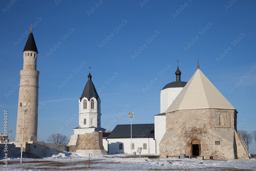 Obraz premium Christianity and Islam together. Big Minaret Complex and Assumtion Church in ruins of Bolgar ancient city on Volga river, archaeological site near Kazan, Tatarstan, Russia
