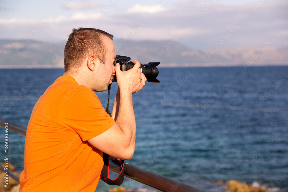 Obraz premium Photographer on beach, summer time. / Guys tourist in nature taking photos Adriatic Sea, Mediterranean, natural environment, enjoying beautiful summer day / Holiday, adventure and travel concept.
