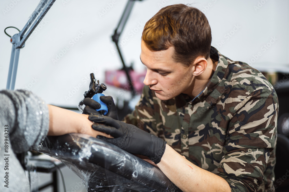 master tattooist makes a tattoo on girl hand master tattooist makes a tattoo on girl hand