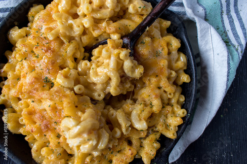 Fotografija gourmet baked macaroni and cheese noodles in rustic cast iron dish top view