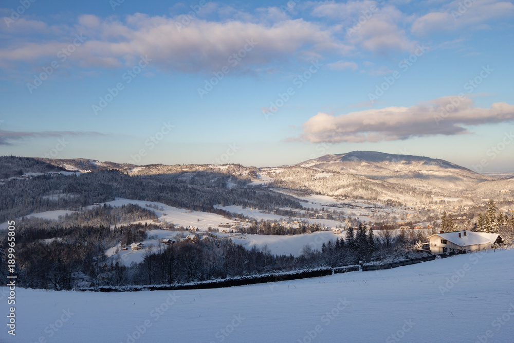 A view of the wooded hills with single houses in the morning winter sun A view of the wooded hills with single houses in the morning winter sun