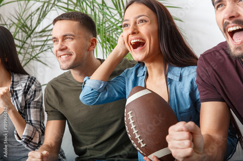 Group of friends sport fans watching rugby match close-up happy