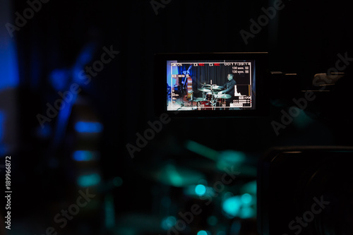 LCD display on the camcorder. Filming of the concert. Musicians playing the double bass and drums.