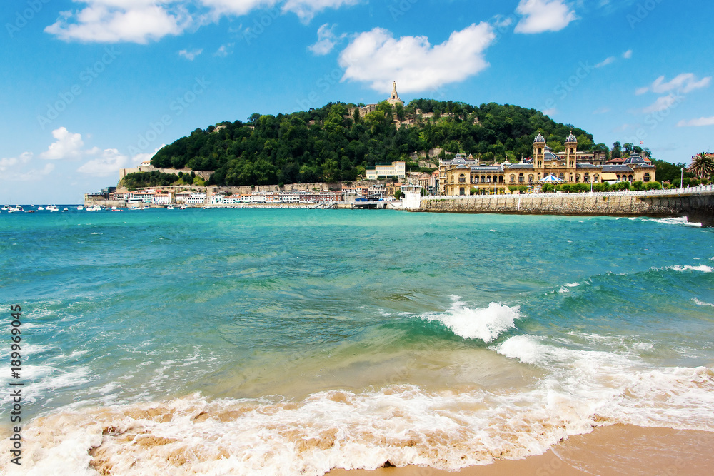 Naklejka premium Widok na piaszczystą plażę w San Sebastian (Donostia), Hiszpania w lovelyl letni dzień. San Sebastian to jedno z najbardziej znanych miejsc turystycznych w Hiszpanii