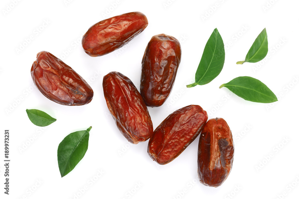 dry dates with green leaves isolated on white background. Top view. Flat lay pattern