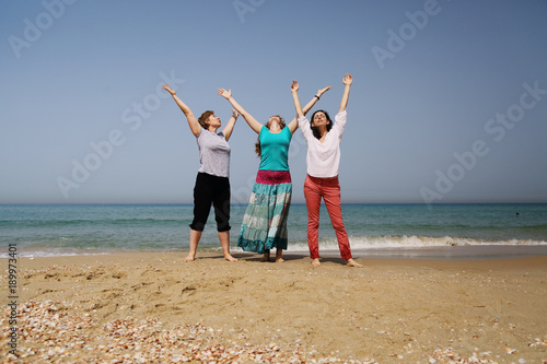 Portrait of three beautiful 40 years old women walking on seaside