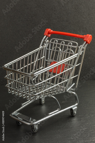 mini metal shopping trolley on black background - focus on front