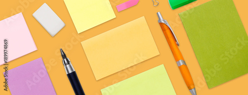 Top view of colorful office and school stationery, isolated on yellow