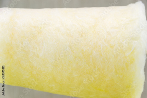 Yellow cotton sweet candy in wooden stick isolated on light coloured background photo