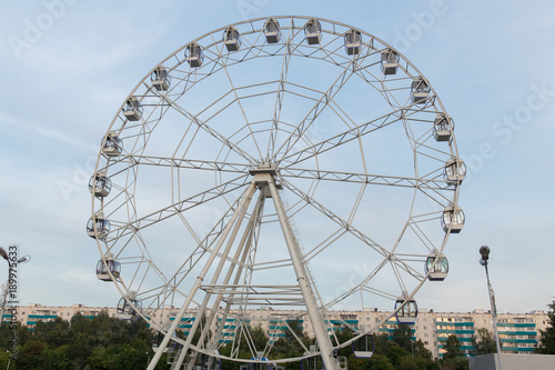 Ferris wheel on a summer day against a high-rise building © lenblr