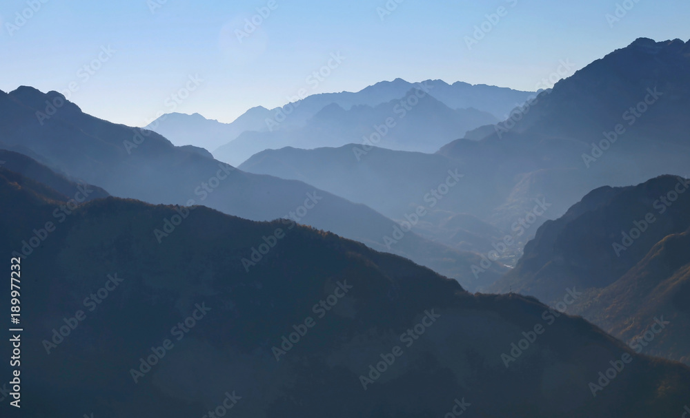 mountain panorama in winter with mountain ranges in the fog