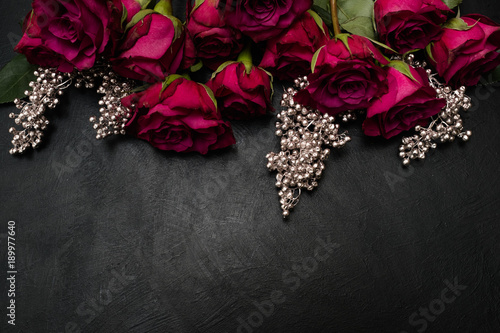 Gothic wedding flowers decor. Dark red or burgundy roses with silver adornment on black background. Bold, daring ,alternative ,and luxury reception party flower arrangement