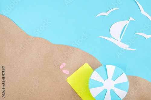 Summer background with sailboat sailing in the sea, gulls, clouds, beach umbrella and mat. Paper cut.