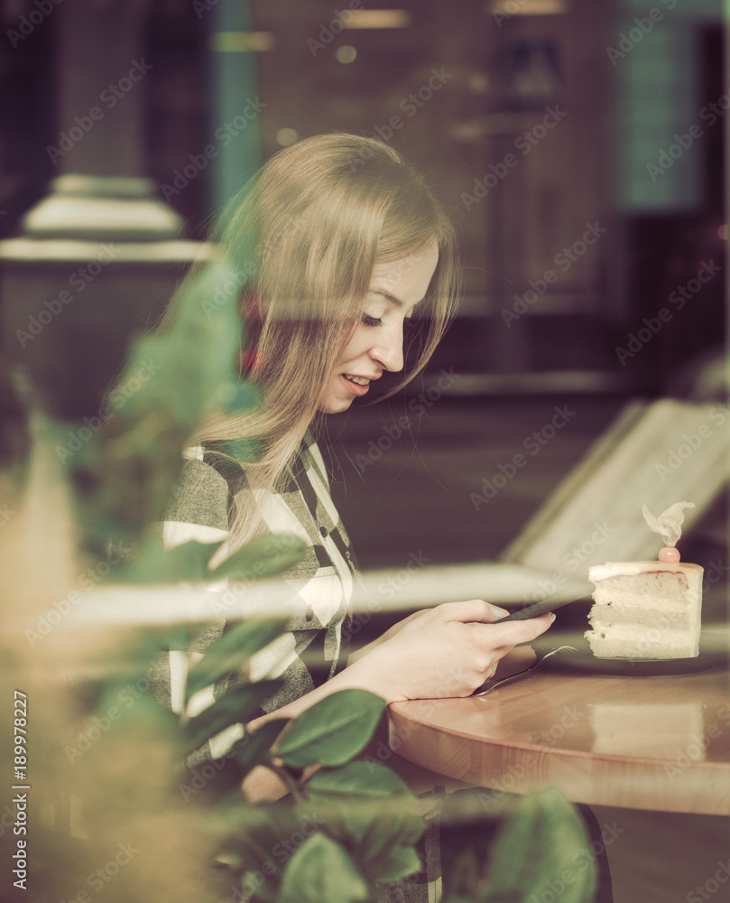 Beautiful girl with a phone in a cafe at the table, Beautiful girl with a phone in a cafe at the table,