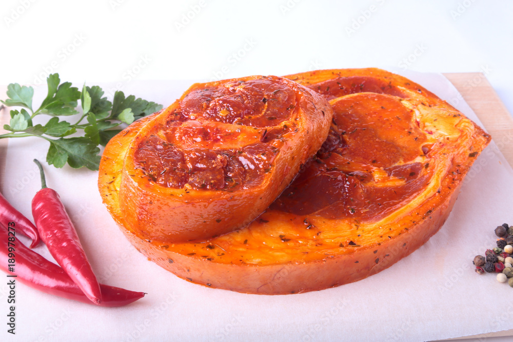 Raw Pork ham with spices, parsley leaves and chilli ready for BBQ grilling isolated on white background. Raw Pork ham with spices, parsley leaves and chilli ready for BBQ grilling isolated on white background.