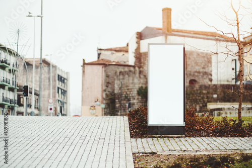 Vertical narrow city information banner mock-up on pavement sidewalk; blank white billboard placeholder in urban settings with copy space place for advertising, text message or your logo, Porto