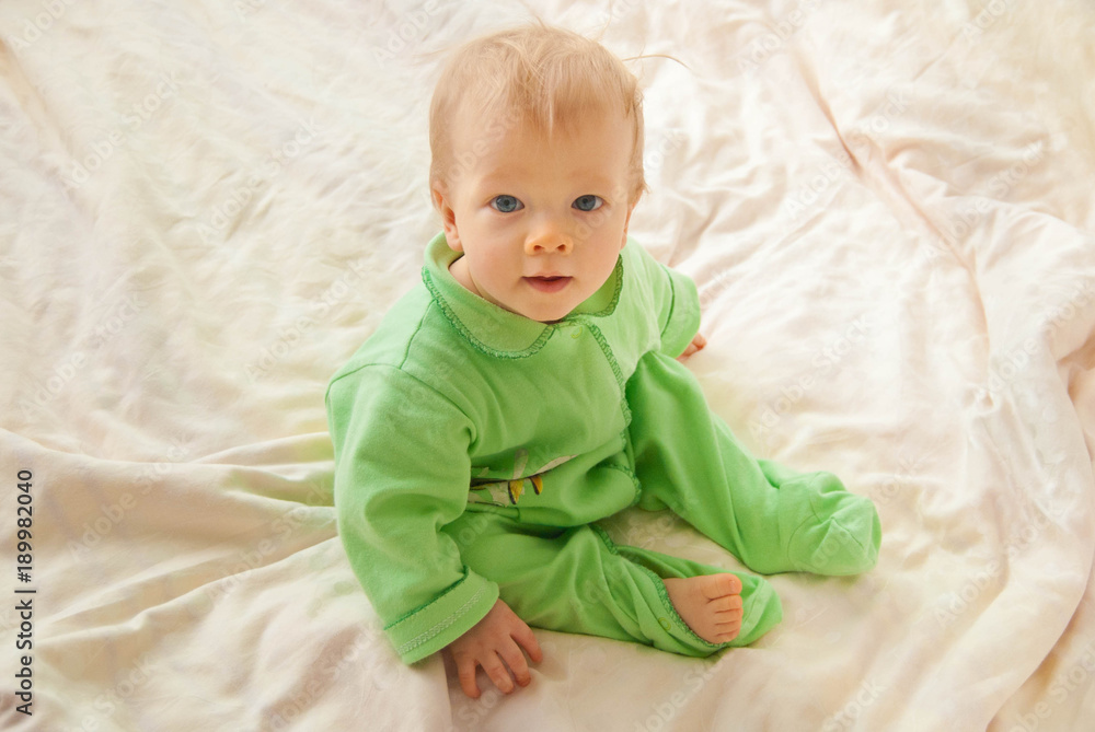 Baby in a sleeping clothes in a bed just wake up
