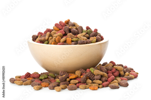 Heap of dry pet food in wooden bowl