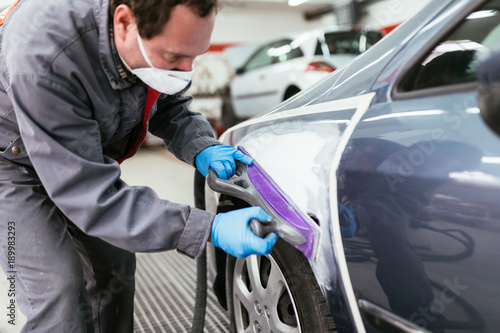 Car detailing - Man preparing car for painting procedure.