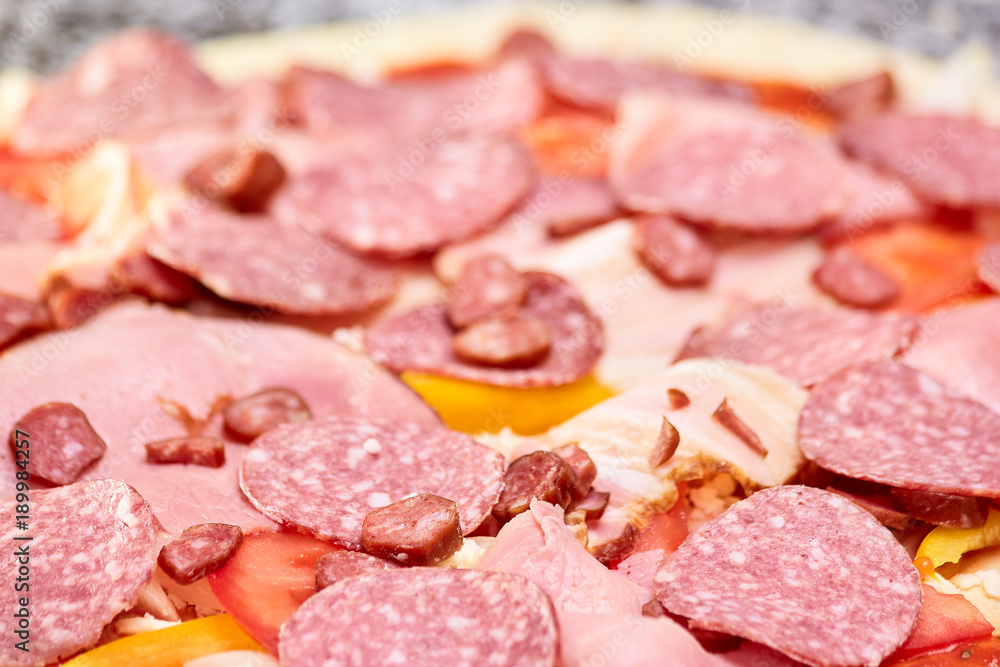 Pile of salamis, hams and hunting sausages closeup. Close up large pile of sliced cold meats.