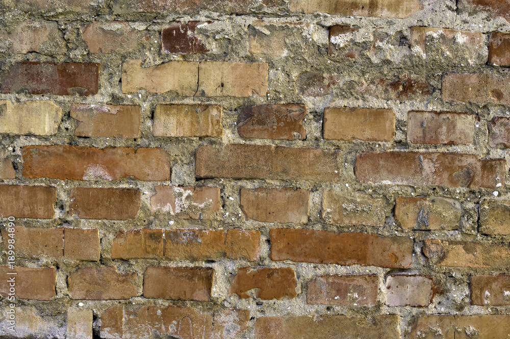 Aged uneven red bricks and concrete wall. Abstract multicolor grunge background with abstract colored texture. Grungy stone wall rectangular surface. Aged uneven red bricks and concrete wall. Abstract multicolor grunge background with abstract colored texture. Grungy stone wall rectangular surface.