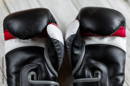 Pair of leather boxing gloves on wooden background. Sport equipment