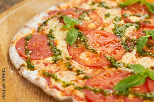 Thin Crust Tomato Pizza, close up. Close up crust of tomato pizza with basil.