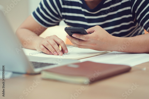 close up student man playing smartphone after hard reading text for test exam   campus life concept