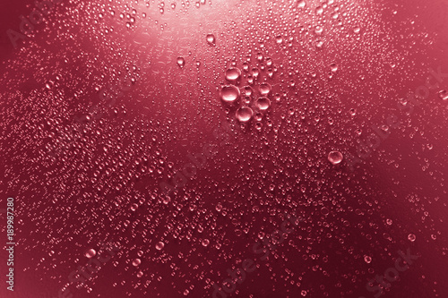 Bubbles of water on a shaded surface  red background