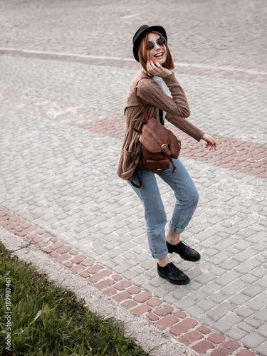Young cheerful woman on the old cobbled street