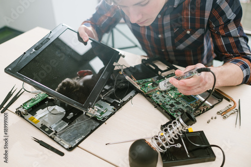 Computer engineer fixing disassembled laptop. Science technology electronics design development