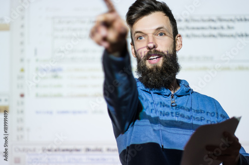 Elocution or speech craft courses. Bearded young male orator interacts with someone in the audience pointing a finger. Dialogue, discussion and rhetoric basics concept